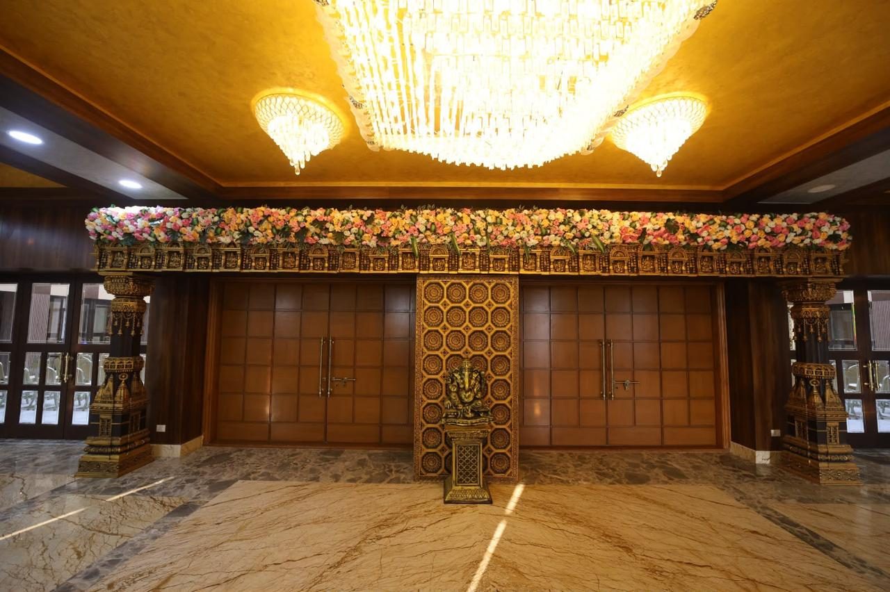 Chandelier-lit lobby entrance with carved wooden doors and floral decor