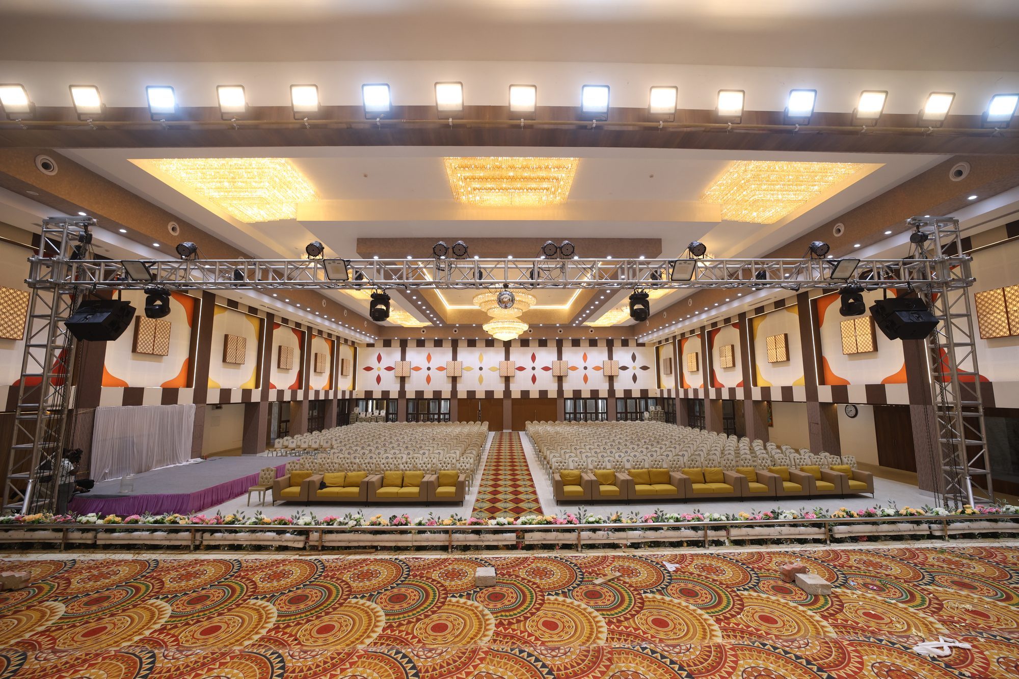 Wide view of the main hall set with rows of guest seating and a stage