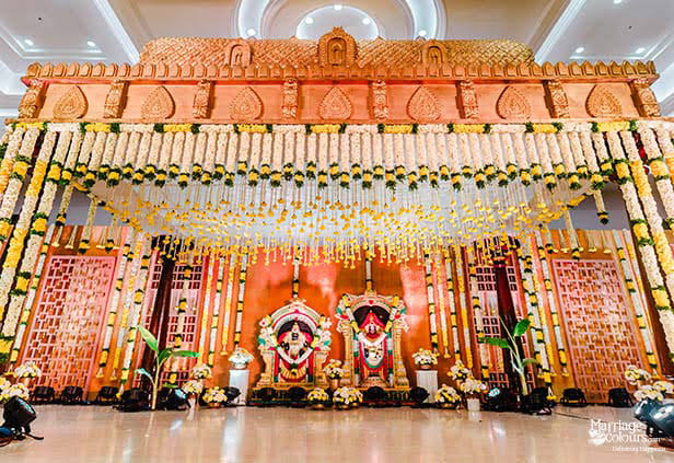 Decorated mandapam stage with floral garlands set up for a wedding ceremony